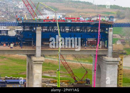 MAANSHAN, CINA - 30 MARZO 2023 - gli operai del secondo ufficio di aviazione della Cina le comunicazioni effettuano il getto concreto per il primo fascio di strada dentro Foto Stock