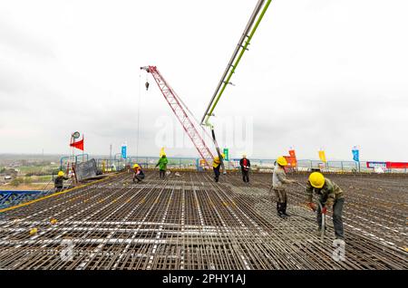 MAANSHAN, CINA - 30 MARZO 2023 - gli operai del secondo ufficio di aviazione della Cina le comunicazioni effettuano il getto concreto per il primo fascio di strada dentro Foto Stock
