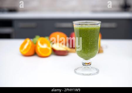 frullato sano in vetro e frutta tutto intorno su tavola di legno Foto Stock