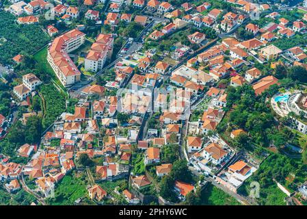 Vista aerea di un vivace quartiere residenziale di Madeira, che mostra l'intricata architettura e le piante lussureggianti. Foto Stock