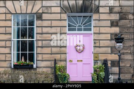 Drummond Place, Edimburgo, Scozia, Regno Unito, 30th marzo 2023. Decorazione della corona di Pasqua: La controversa porta rosa della Città Nuova è decorata per Pasqua. Il proprietario, Miranda Dickson, è stato detto dal consiglio comunale di Edimburgo che deve cambiare il colore nel sito patrimonio dell'umanità dell'UNESCO entro aprile o rischiare una multa, dopo aver perso un appello al governo scozzese. Credit: Sally Anderson/Alamy Live News Foto Stock