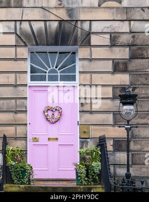 Drummond Place, Edimburgo, Scozia, Regno Unito, 30th marzo 2023. Decorazione della corona di Pasqua: La controversa porta rosa della Città Nuova è decorata per Pasqua. Il proprietario, Miranda Dickson, è stato detto dal consiglio comunale di Edimburgo che deve cambiare il colore nel sito patrimonio dell'umanità dell'UNESCO entro aprile o rischiare una multa, dopo aver perso un appello al governo scozzese. Credit: Sally Anderson/Alamy Live News Foto Stock