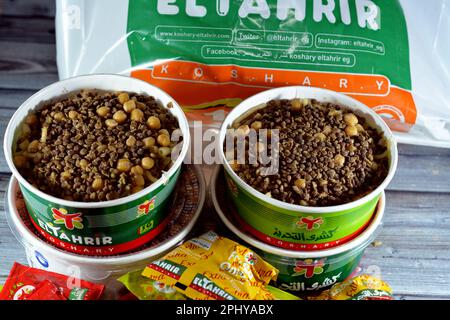 Cairo, Egitto, 28 2023 marzo: El Tahrir Koshary Koshari, cibo di strada di riso, maccheroni, spaghetti e lenticchie mescolati con una salsa di pomodoro speziata, Foto Stock