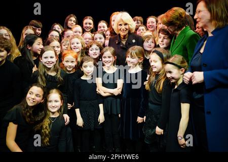 La Regina Consort e la First Lady Elke Budenbender (giacca verde) posano per una foto con un gruppo di scolaresche dopo la loro esecuzione alla Komische Opera Berlin, durante il secondo giorno la visita del Re e della Regina in Germania. Data immagine: Giovedì 30 marzo 2023. Foto Stock