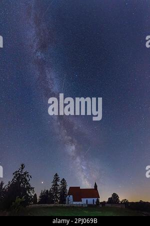 Cielo notturno con stelle sopra il villaggio deserto di Gruorn, la Via Lattea sopra St Chiesa di Stephens, Alb Svevo, Muensingen, Baden-Wuerttemberg Foto Stock