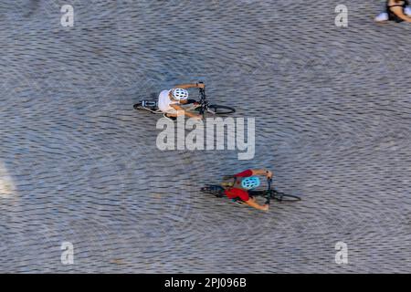 Uccelli vista di persone, due ciclisti con caschi cavalcano su una piazza con ciottoli, foto simbolo, Stoccarda, Baden-Wuerttemberg, Germania Foto Stock