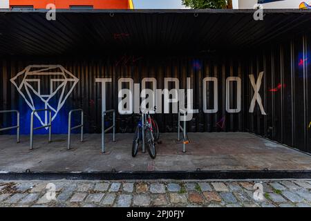 Wroclaw, Polonia - Giugno 2022: Garage per biciclette costituito da un vecchio grande contenitore di spedizione dipinto all'interno con un grande logo Tooplox Foto Stock