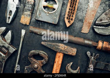 Vecchi strumenti hardware. Chiave, cacciavite, misurino, martello, pinze su superficie in acciaio. Attrezzi meccanici per la manutenzione. Strumenti hardware da correggere Foto Stock