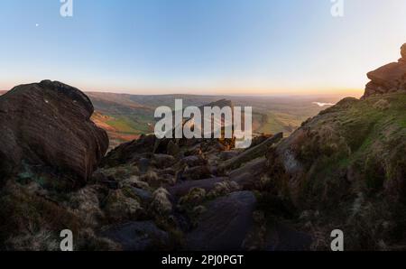 Guardando dalle rocce sui Roaches verso la formazione di galline nuvola nella campagna dello Staffordshire nel Peak District inglese, al tramonto Foto Stock