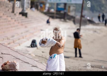 Santo Rishikesh, Ritratto di vecchio brahmin maschio non identificato a piedi vicino al fiume ganges a rishikesh durante la mattina d'inverno indossando abiti tradizionali. Foto Stock