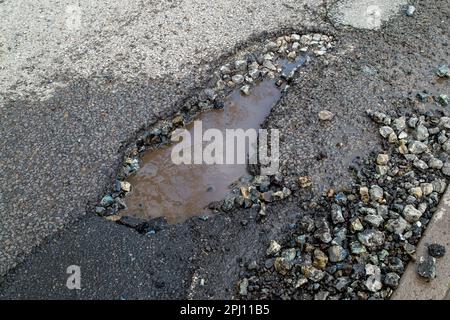 Dorney, Regno Unito. 30th marzo, 2023. Un'altra nuova pozia profonda sulla Village Road a Dorney, Buckinghamshire. Purtroppo molte buche in Dorney sono solo patched up da Buckinghamshire Council appaltatori, in modo entro poche settimane dopo la pioggia e il freddo tempo, le buche tornano. Questa sera, le auto stavano nuotando nel percorso dei veicoli in arrivo durante l'ora di punta per evitare questa poesia. Il governo ha stanziato altri £200 milioni di dollari per le riparazioni delle buche nel periodo 2023-2024. Credit: Maureen McLean/Alamy Live News Foto Stock