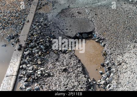 Dorney, Regno Unito. 30th marzo, 2023. Un'altra nuova pozia profonda sulla Village Road a Dorney, Buckinghamshire. Purtroppo molte buche in Dorney sono solo patched up da Buckinghamshire Council appaltatori, in modo entro poche settimane dopo la pioggia e il freddo tempo, le buche tornano. Questa sera, le auto stavano nuotando nel percorso dei veicoli in arrivo durante l'ora di punta per evitare questa poesia. Il governo ha stanziato altri £200 milioni di dollari per le riparazioni delle buche nel periodo 2023-2024. Credit: Maureen McLean/Alamy Live News Foto Stock