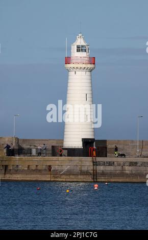 Donaghadee, County Down, Irlanda del Nord, Regno Unito. 30 Mar 2023. Tempo nel Regno Unito – un pomeriggio di sole sulla costa orientale dell'Irlanda del Nord con temperature che raggiungono i 14C°C. Tuttavia, c'è il rischio di una doccia pesante e occasionale. Nuoto in mare aperto e nuotatori nel Mare d'Irlanda a Donaghadee. Credit: David Hunter/Alamy Live News. Foto Stock