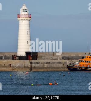 Donaghadee, County Down, Irlanda del Nord, Regno Unito. 30 Mar 2023. Tempo nel Regno Unito – un pomeriggio di sole sulla costa orientale dell'Irlanda del Nord con temperature che raggiungono i 14C°C. Tuttavia, c'è il rischio di una doccia pesante e occasionale. Nuoto in mare aperto e nuotatori nel Mare d'Irlanda a Donaghadee. Credit: David Hunter/Alamy Live News. Foto Stock