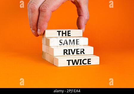 Lo stesso fiume due volte simbolo. Concetto parole lo stesso fiume due volte su blocco di legno. Bella tavola arancione sfondo arancione. Business motivazionale il s Foto Stock