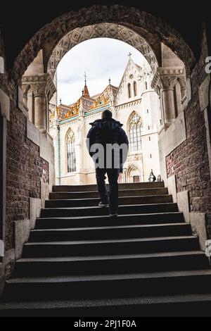 Un uomo che arriva al Bastione dei pescatori nel cuore del quartiere del Castello di Buda a Budapest, Ungheria Foto Stock