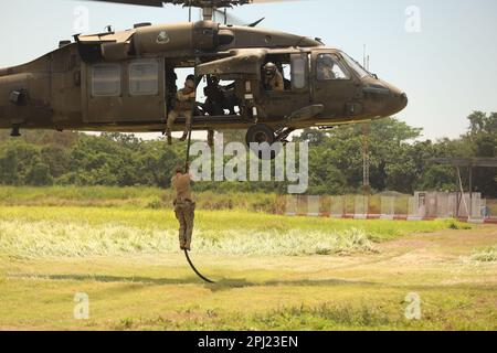 L'istruttore di FOCHE della Marina Ropes veloci da un Blackhawk UH60 per l'addestramento DELLE PATATINE FRITTE durante il CentMam Guardian 23 a San Jose, Guatemala il 21 marzo 2023. CG23 è un esercizio annuale congiunto, interagenzia e multinazionale di costruzione di partnership guidato dall'Esercito, progettato per costruire capacità, capacità e interoperabilità con le nazioni partner dell'America Centrale. (STATI UNITI Foto dell'esercito di Sgt. 1st Classe Iman Broady-Chin) Foto Stock