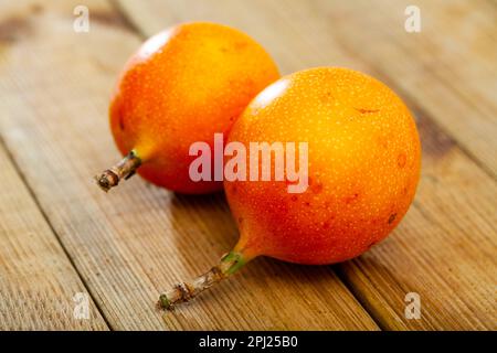 Frutta intera e mezza granadilla fresco su tavola di legno Foto Stock