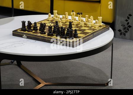Pezzi di scacchi in legno disposti su una scacchiera Foto Stock