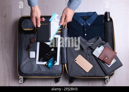 Valigia uomo per viaggi di lavoro su pavimento in legno, vista dall'alto Foto Stock