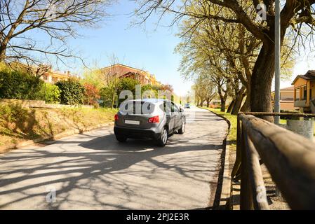 Vista pittoresca di bella strada suburbana con auto in sole giornata di primavera Foto Stock