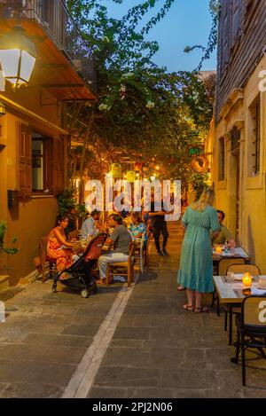 Rethimno, Grecia, 20 agosto 2022: Tramonto vista di persone che passeggiando in una strada turistica nella città greca Rethimno a Creta isola. Foto Stock