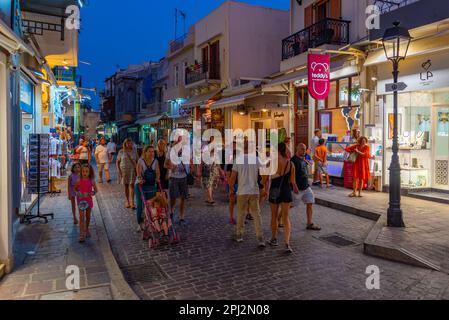 Rethimno, Grecia, 20 agosto 2022: Tramonto vista di persone che passeggiando in una strada turistica nella città greca Rethimno a Creta isola. Foto Stock