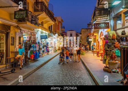 Rethimno, Grecia, 20 agosto 2022: Tramonto vista di persone che passeggiando in una strada turistica nella città greca Rethimno a Creta isola. Foto Stock