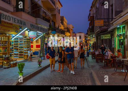 Rethimno, Grecia, 20 agosto 2022: Tramonto vista di persone che passeggiando in una strada turistica nella città greca Rethimno a Creta isola. Foto Stock