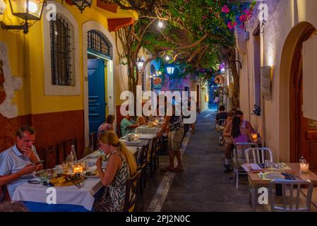 Rethimno, Grecia, 20 agosto 2022: Tramonto vista di persone che passeggiando in una strada turistica nella città greca Rethimno a Creta isola. Foto Stock