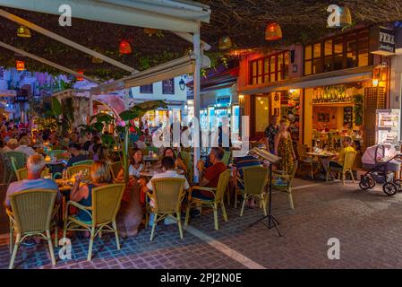 Rethimno, Grecia, 20 agosto 2022: Tramonto vista di persone che passeggiando in una strada turistica nella città greca Rethimno a Creta isola. Foto Stock