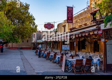 Rodi, Grecia, 25 agosto 2022: Vista all'alba di una strada turistica nella città greca Rodi. Foto Stock
