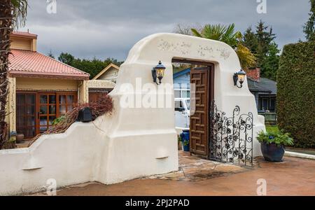 Cancello d'ingresso in fango e argilla. Arco tradizionale stile mediterraneo. Ingresso nel cortile anteriore di una casa. Foto strada, nessuno, selettiva f Foto Stock