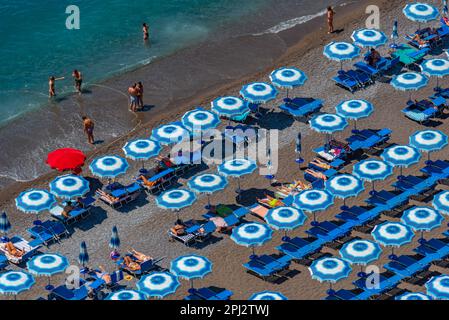 Positano, Italia, 21 maggio 2022: Ombrelloni bianchi e blu sulla spiaggia di Positano in Italia. Foto Stock