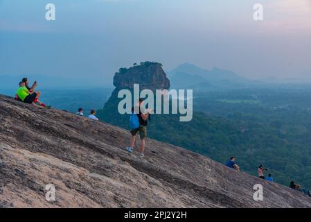 Sigiriya, Sri Lanka, 4 febbraio 2022: Gruppo di giovani gode di una vista al tramonto della fortezza rocciosa di Sigiriya in Sri Lanka. Foto Stock