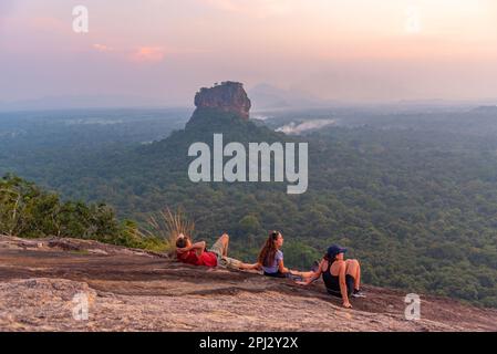 Sigiriya, Sri Lanka, 4 febbraio 2022: Gruppo di giovani gode di una vista al tramonto della fortezza rocciosa di Sigiriya in Sri Lanka. Foto Stock