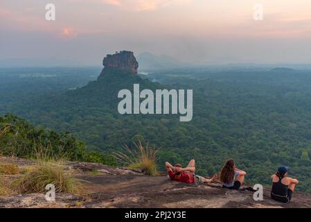 Sigiriya, Sri Lanka, 4 febbraio 2022: Gruppo di giovani gode di una vista al tramonto della fortezza rocciosa di Sigiriya in Sri Lanka. Foto Stock