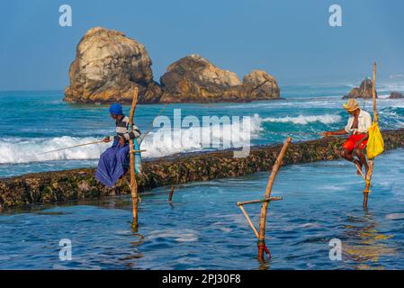 Koggala, Sri Lanka, 21 gennaio 2022: Vista al tramonto dei tradizionali pescatori di palafitte a Koggala, Sri Lanka. Foto Stock