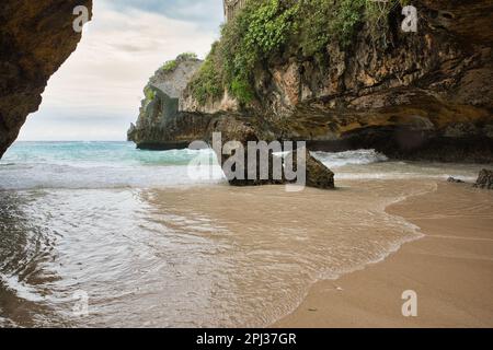 La spiaggia di Suluban a Bali, Indonesia, racchiusa in una baia di rocce maestose. Foto Stock