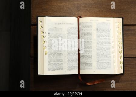 Aprire la Bibbia su un tavolo di legno, vista dall'alto. Libro religioso cristiano Foto Stock