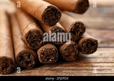 Sigari avvolti in foglie di tabacco su tavola di legno, primo piano Foto Stock