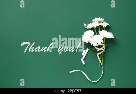 Grazie insegnante! Bellissimi fiori e pezzi di gesso su lavagna verde, piatto Foto Stock