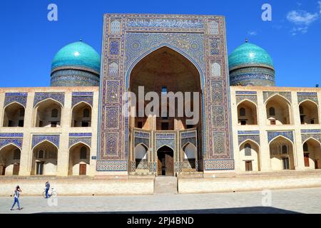 Uzbekistan, Bukhara: Facciata e iwan della medrasa araba Mir-i nel complesso po-i-Kalyan con le sue cupole piastrellate blu fiancheggianti. La costruzione è un credito Foto Stock