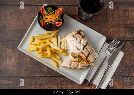 Involtini di pollo con patatine fritte e insalata Foto Stock