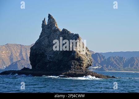 Oman, Muscat: Inusuale sperone roccioso nero al largo della costa ad est di Muscat. Foto Stock