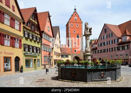 Germania, Baviera, Mittelfranken, Dinkelsbühl: Mercato e Fontana del Leone con Wörnitz Tor, la porta orientale della città, sullo sfondo. Foto Stock