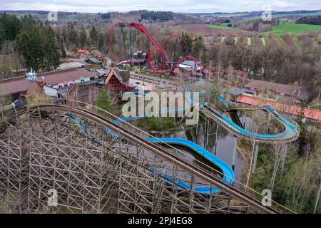 Lengenfeld, Germania. 31st Mar, 2023. Le montagne russe 'El Torro' (di fronte) e 'Dynamite' e il giro in acqua bianca al parco divertimenti Plohn si svegliano dall'ibernazione. Dopo la pausa invernale, i parchi divertimenti della Sassonia riaprono i visitatori in questi giorni, invitandoli a fare giri su giostre, montagne russe e ruote. Il parco della regione di Vogtland offre circa 80 attrazioni e sei montagne russe. La stagione inizia il Giovedi Maundy (6 aprile). (Vista aerea con drone) Credit: Jan Woitas/dpa/Alamy Live News Foto Stock