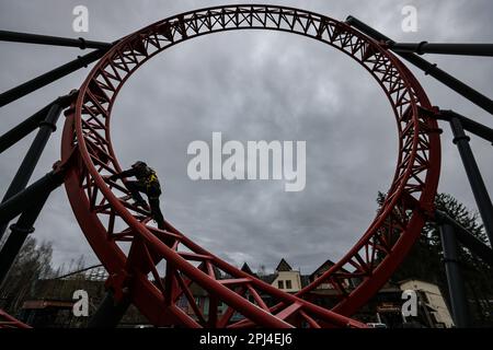 Lengenfeld, Germania. 31st Mar, 2023. Marco Willhelm, meccanico di manutenzione del parco divertimenti Plohn, controlla i collegamenti imbullonati delle montagne russe 'Dynamite' prima dell'inizio della stagione. Dopo la pausa invernale, i parchi divertimenti della Sassonia riaprono i visitatori in questi giorni, invitandoli a fare giri su giostre, montagne russe e ruote. Il parco della regione di Vogtland offre circa 80 attrazioni e sei montagne russe. La stagione inizia il Giovedi Maundy (6 aprile). Credit: Jan Woitas/dpa/Alamy Live News Foto Stock