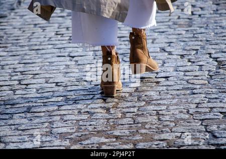 piedi di una donna che cammina negli stivali Foto Stock