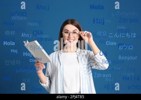 Ritratto di traduttore felice e parole di saluto in diverse lingue straniere su sfondo azzurro Foto Stock